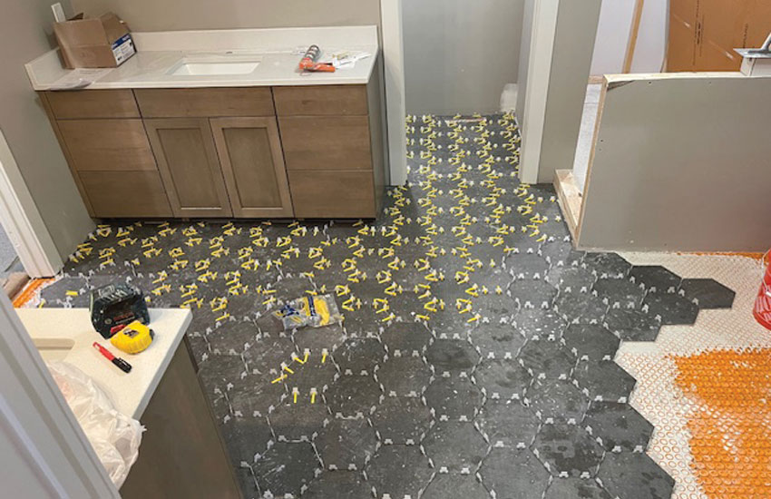 Long Lake bathroom floor before renovation detail - damaged floor tile