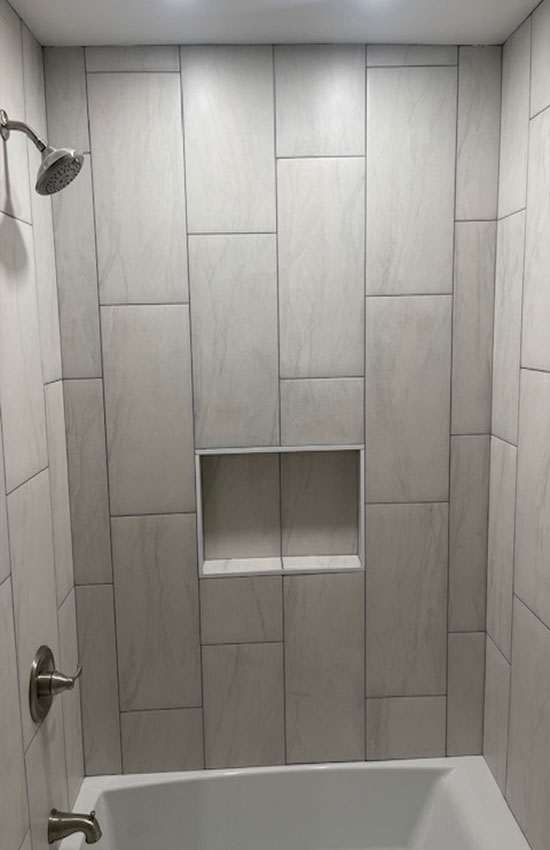 Washburn bathroom walk-in glass shower with brass shower head and handles by Garrett Construction